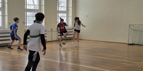 Powiększ grafikę: Uczniowie podczas gry w piłkę nożną w sali gimnastycznej.