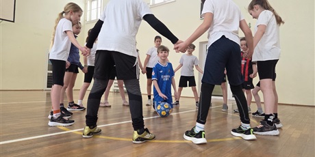 Powiększ grafikę: Uczniowie podczas gry w piłkę nożną w sali gimnastycznej.